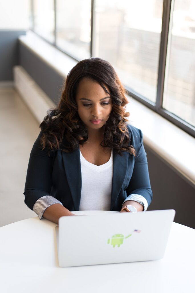 Woman works on a laptop with an Android sticker.