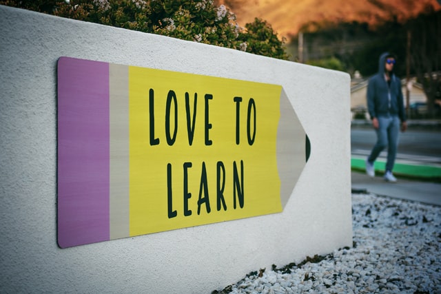 Love to Learn sign depicted on sign that looks like a giant pencil.